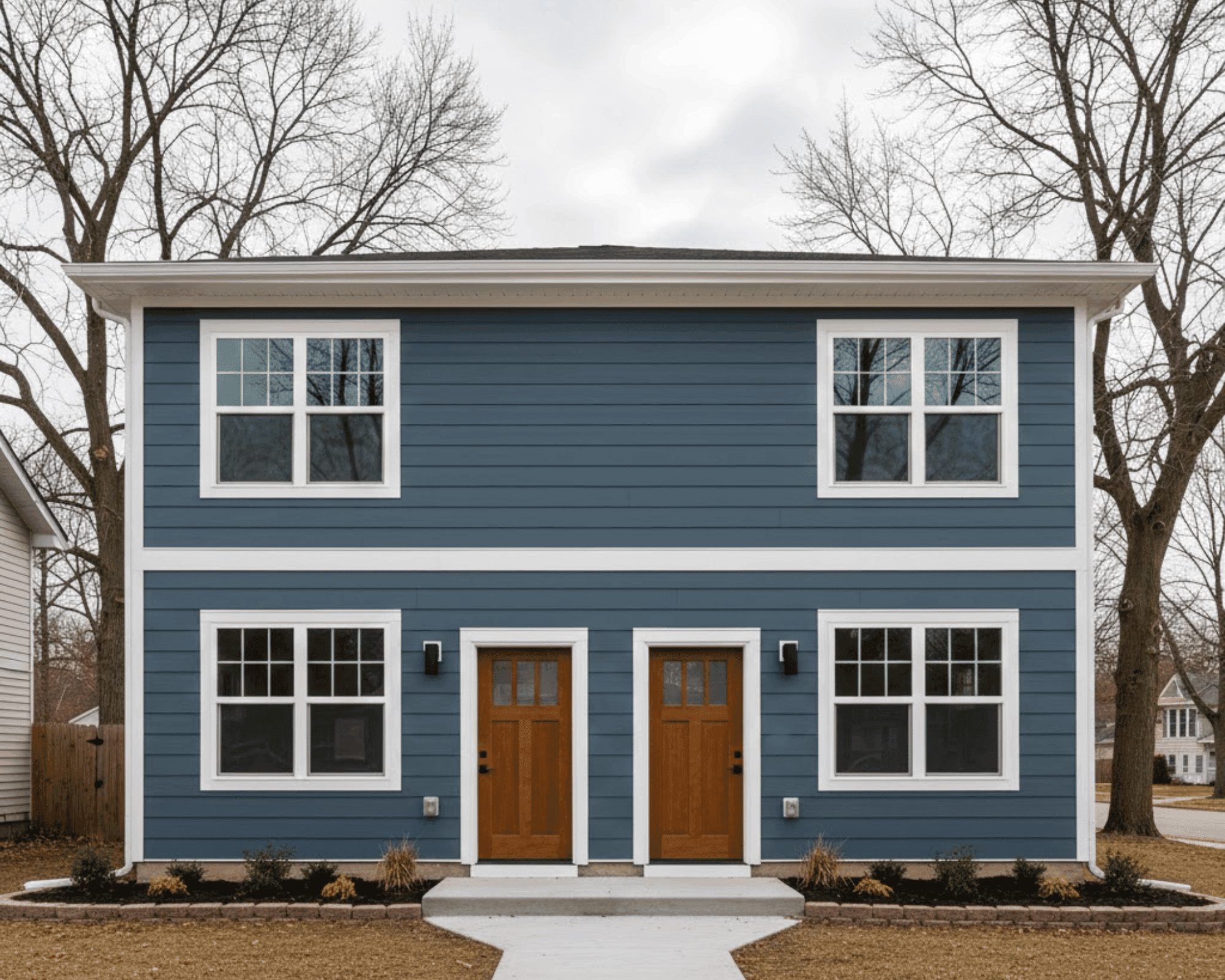 Renovated duplex exterior with blue siding and craftsman doors