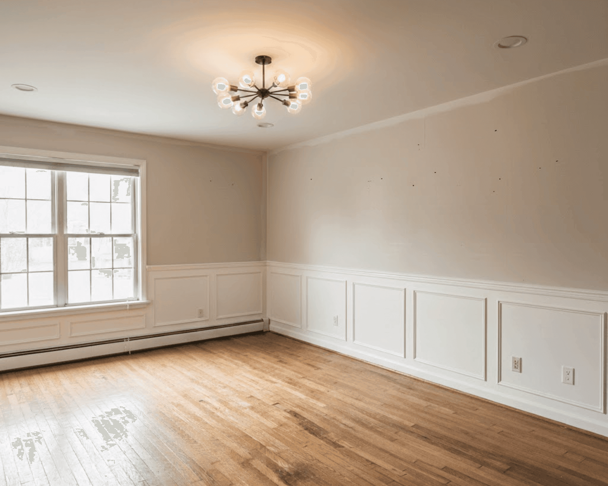 Beautifully restored room with new wainscoting and fixtures after water damage
